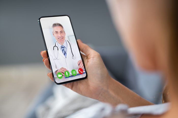 Person Videochatting With Doctor On Mobile Phone