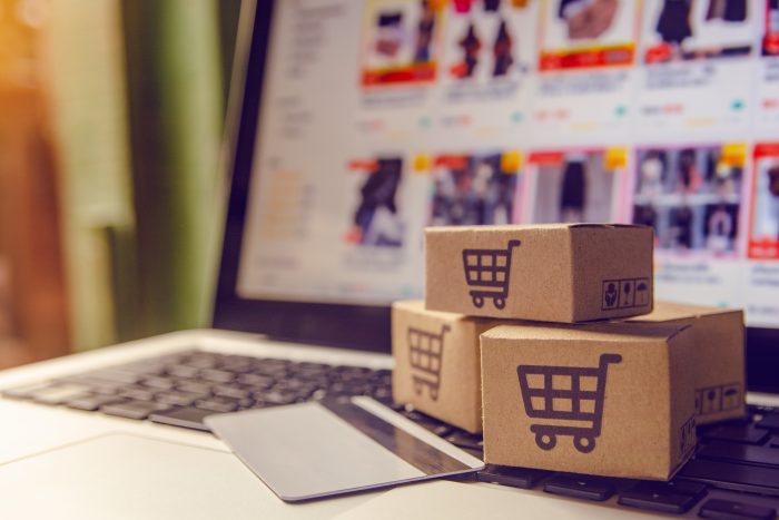 Shopping online concept - Shopping service on The online web. with payment by credit card and offers home delivery. parcel or Paper cartons with a shopping cart logo on a laptop keyboard