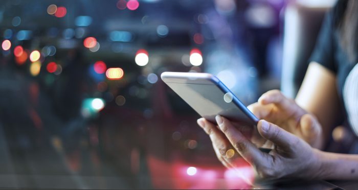 Woman using mobile smart phone in the night light colorful background